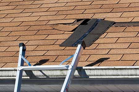 nail gun and asphalt shingles being installed